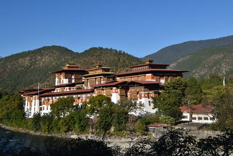 The Punakha Dzong, a majestic fort on a riverbank with mountain backdrop.