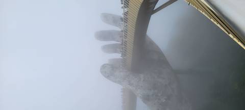 Golden Bridge with stone hands in foggy weather.