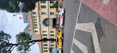 Crowded street outside a historical building with taxis.
