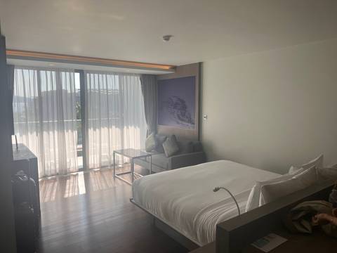       Hotel room with a large bed and window view.
  