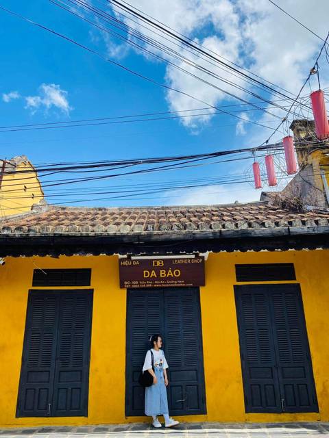       Street view of a traditional building with a leather shop sign.
  