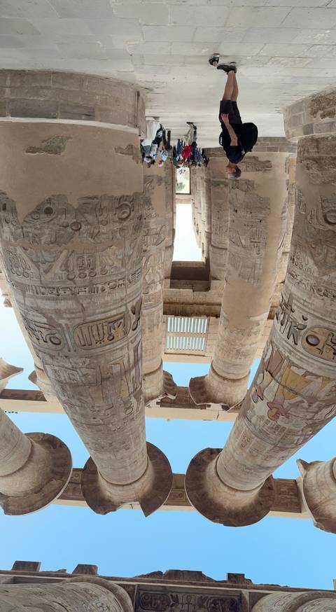 Visitors exploring an ancient temple with tall columns.