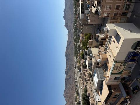 Urban landscape with buildings and mountains in the background.