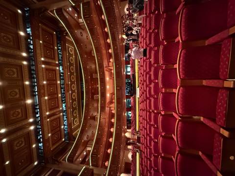 Interior of a grand theater with red seating and intricate decor.
