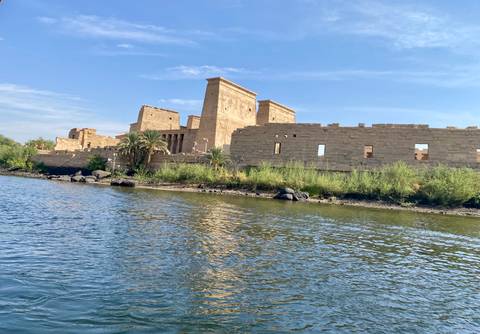       Ancient temple ruins along a riverbank under a clear sky.
  