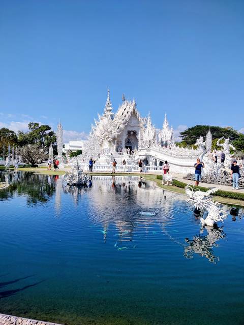       The White Temple with tourists walking around.
  