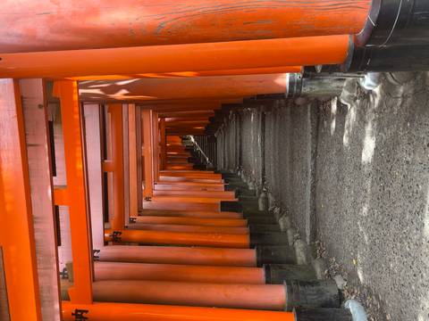 Red torii gates forming a tunnel entrance to a shrine.