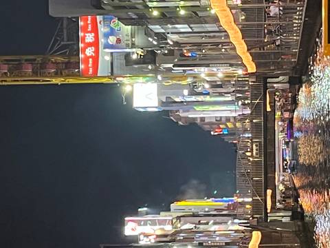 Night view of a bridge over a canal surrounded by lit-up buildings.
