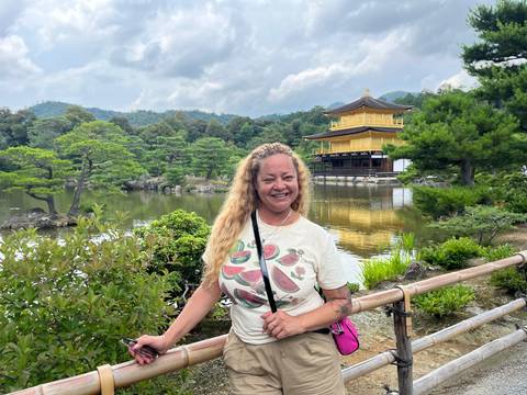 Woman standing in front of the Golden Pavilion, Kinkaku-ji.