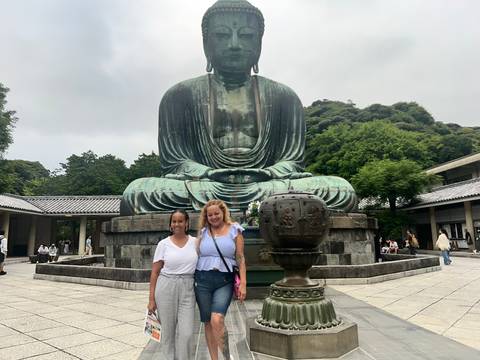 Two people posing in front of The Great Buddha statue.
