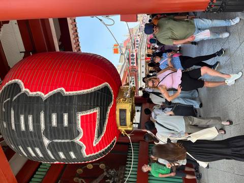 Person posing with a large red Japanese lantern.