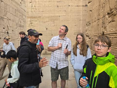 Group learning about ancient carvings on stone walls.