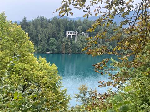 View of a turquoise lake surrounded by trees.
