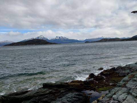 Coastal view with mountains in the distance under overcast skies.