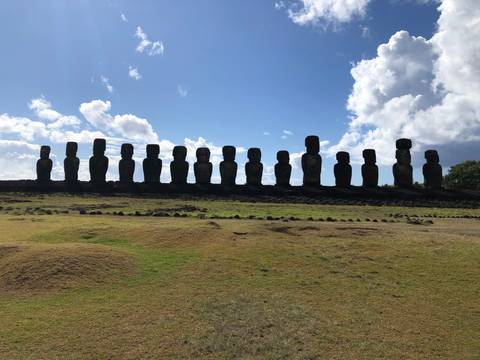 Silhouette of moai statues against the sky.