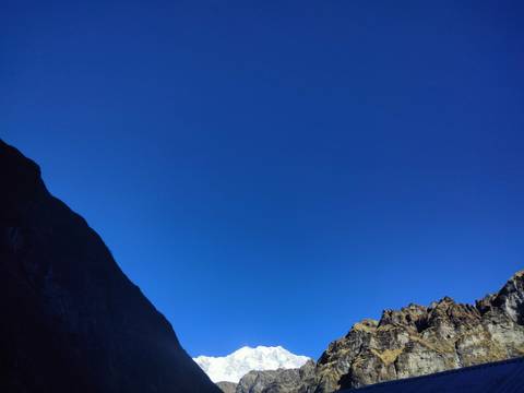 Clear blue sky with mountain peaks at the bottom edge.