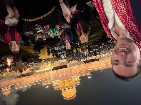 Family dining outdoors in a well-lit setting with a grand building behind.