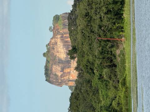       Famous rock formation surrounded by lush greenery and water.
  