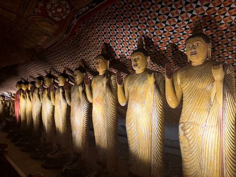 Statues in a temple with intricate wall designs.