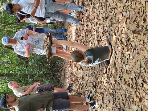 Tourists exploring an underground entrance in the Cu Chi tunnels.