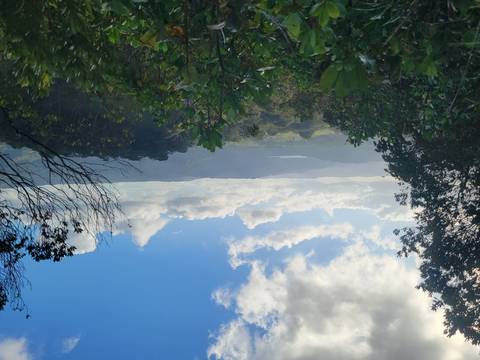 Landscape view of lush green valleys and hills under a partly cloudy sky in Costa Rica.