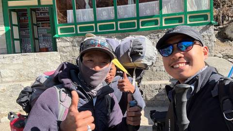 Group of people giving thumbs up, wearing trekking gear.