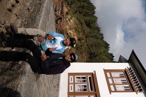 Two men sitting outside a house in a mountain village.