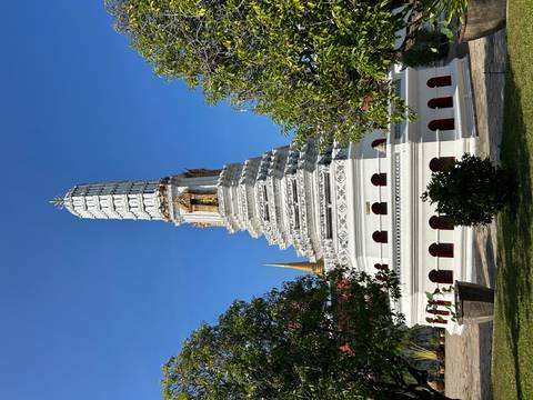       White stupa with intricate carvings and golden accents.
  