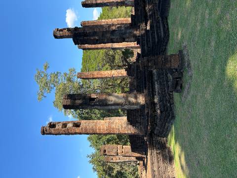       Ancient ruins of stone columns under clear sky.
  