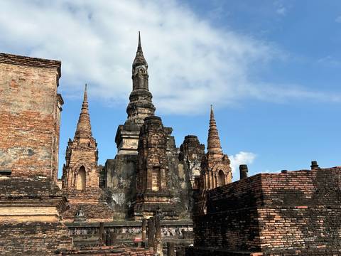       Historic temple spires and stonework against a blue sky.
  
