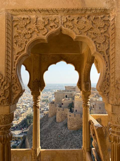 Scenic view through ornate archways overlooking an ancient fort.