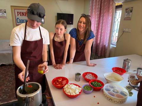 Family participating in a cooking class with various ingredients.