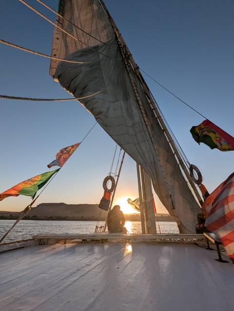 Sailboat on the water during sunset with flags.