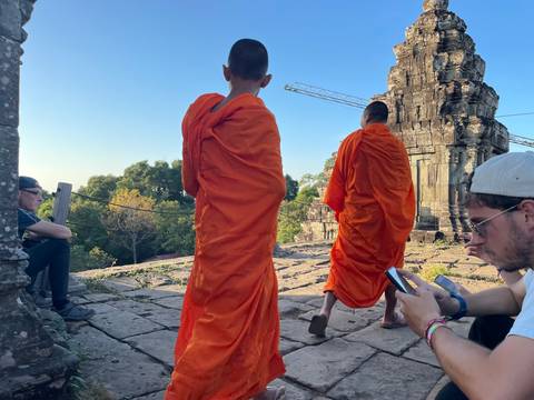       Monks in orange robes walking near ancient ruins
  