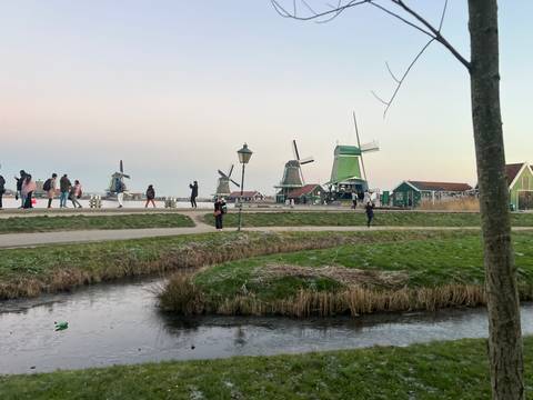 Picturesque scene of windmills with people walking on a path.