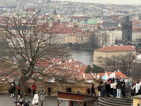 Panoramic view of Prague city with tourists in the foreground.