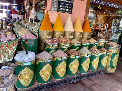 Colorful spice market display with various spices and cones.