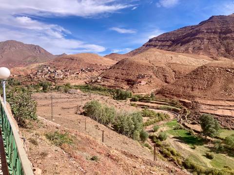Hilly landscape with a small village and greenery.