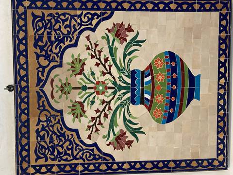 Mosaic art featuring a colorful vase with flowers.