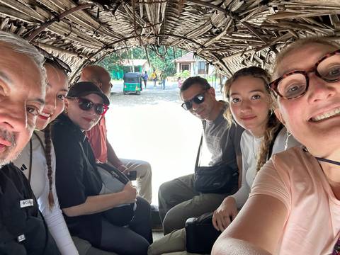 Group seated inside a rustic vehicle enjoying a ride.