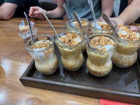       Multiple glass cups filled with a creamy coffee and topped with flakes.
  