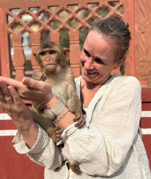       Woman holding a small monkey affectionately.
  