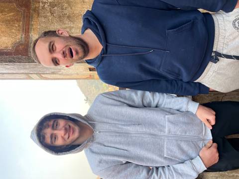       Two young men smiling and posing for a picture.
  