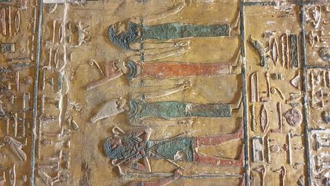 Ancient Egyptian carvings on a stone wall.