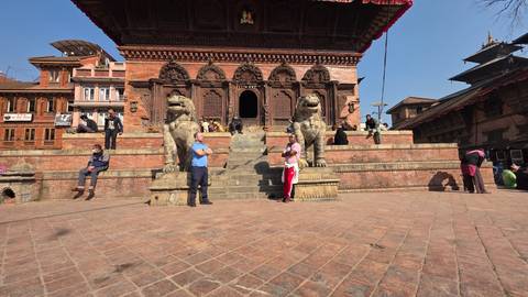 People and lion statues at an ancient temple.
