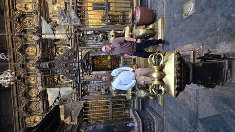 Two people at a historic site, standing between stone lions.