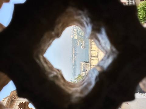 Distant view of cityscape through a decorative opening.