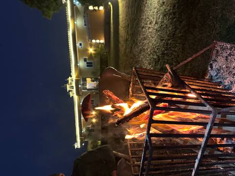       Outdoor fire pit with a house in the background at night.
  