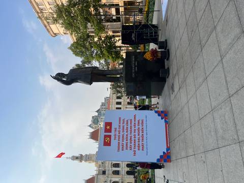 Statue and political banners in a city square.