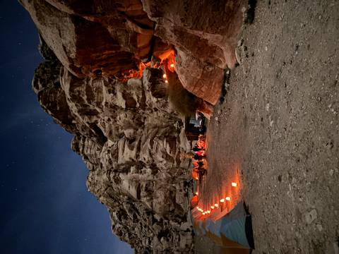       Campsite with glowing lanterns in a rocky desert environment.
  